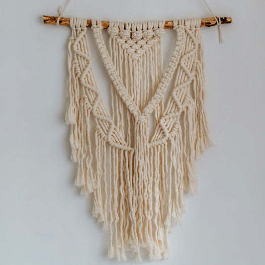 Macrame wall hanging on a plain white wall