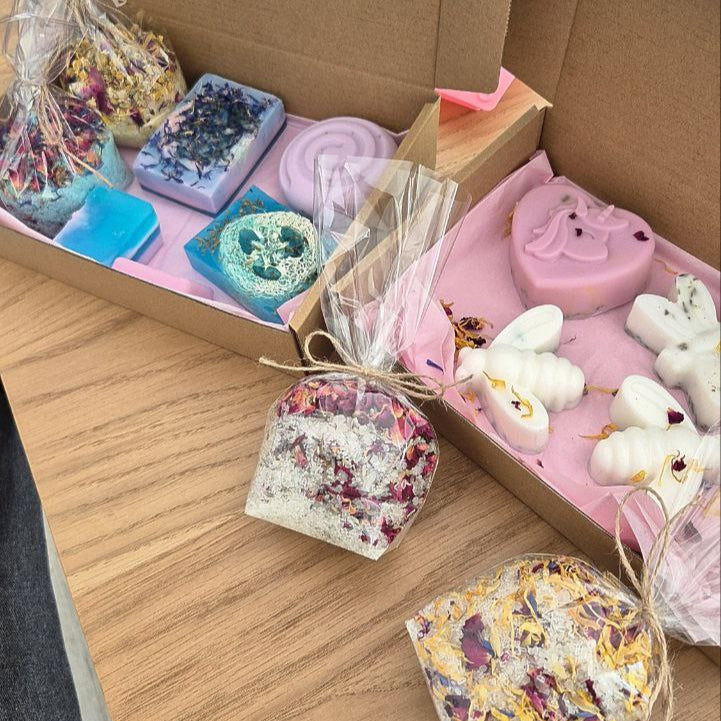 Box of assorted soaps and bath bombs on a wooden surface